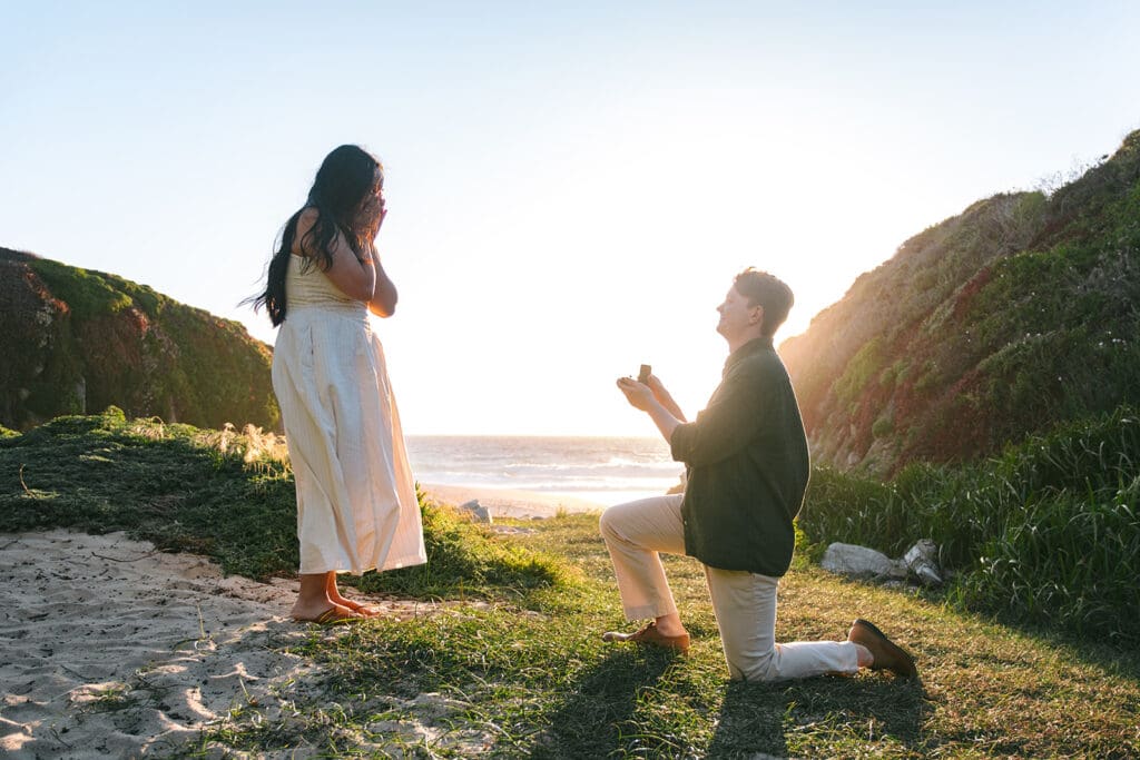 Man down on one knee proposing in Big Sur