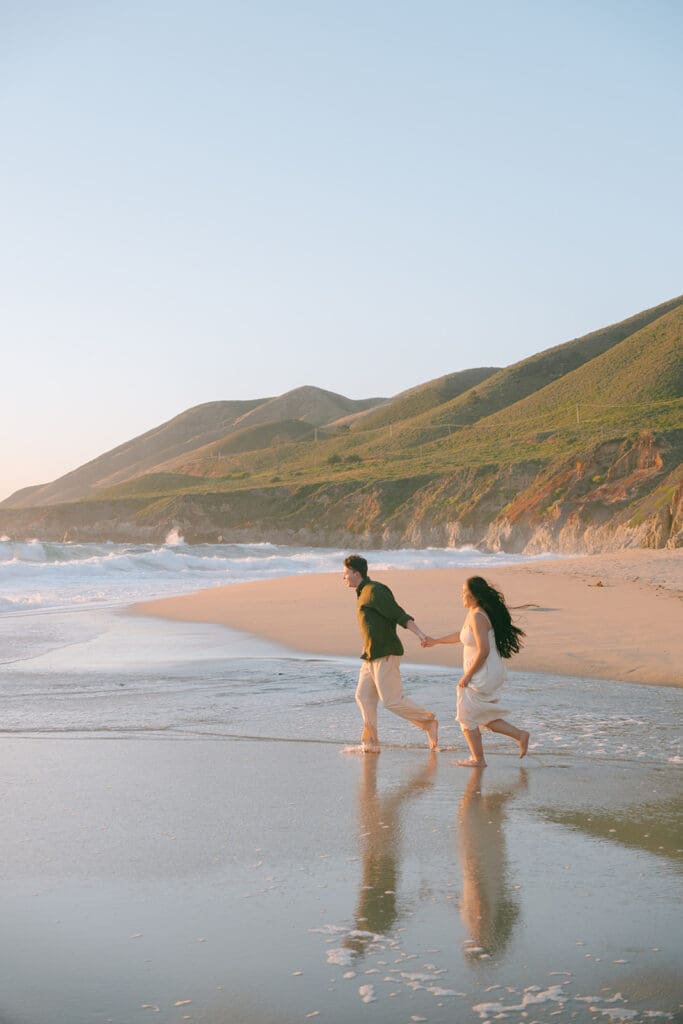 couple running on the beach in Big Sur