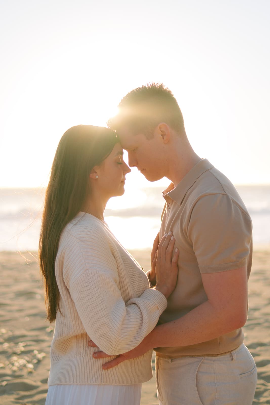 Couple hugging on Garrapata Beach at golden hour